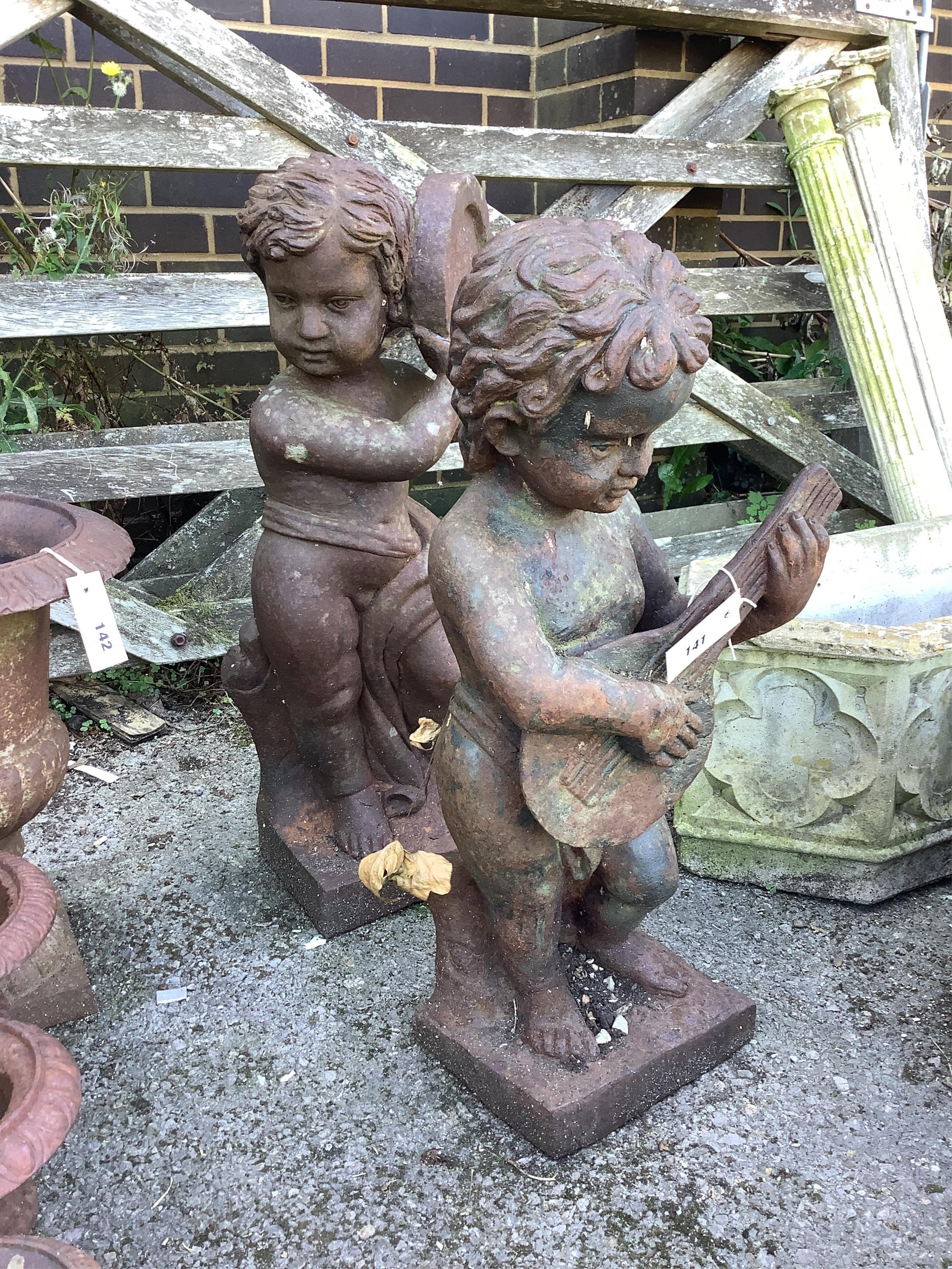 A pair of cast iron musical putti garden ornaments, larger height 68cm. Condition - fair